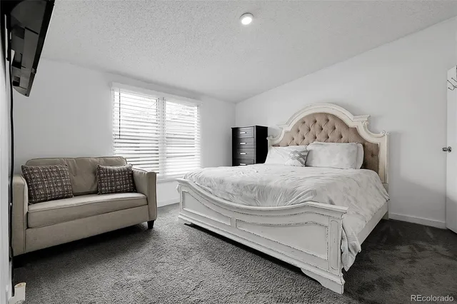 a bedroom with bed couch and window