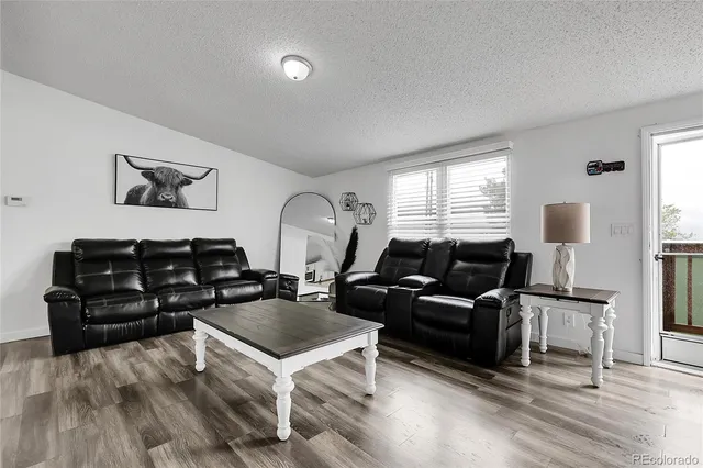 a living room with furniture and wooden floor