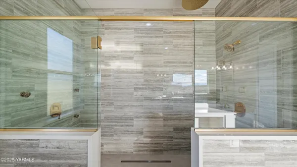 a bathroom with a double vanity sink mirror and shower