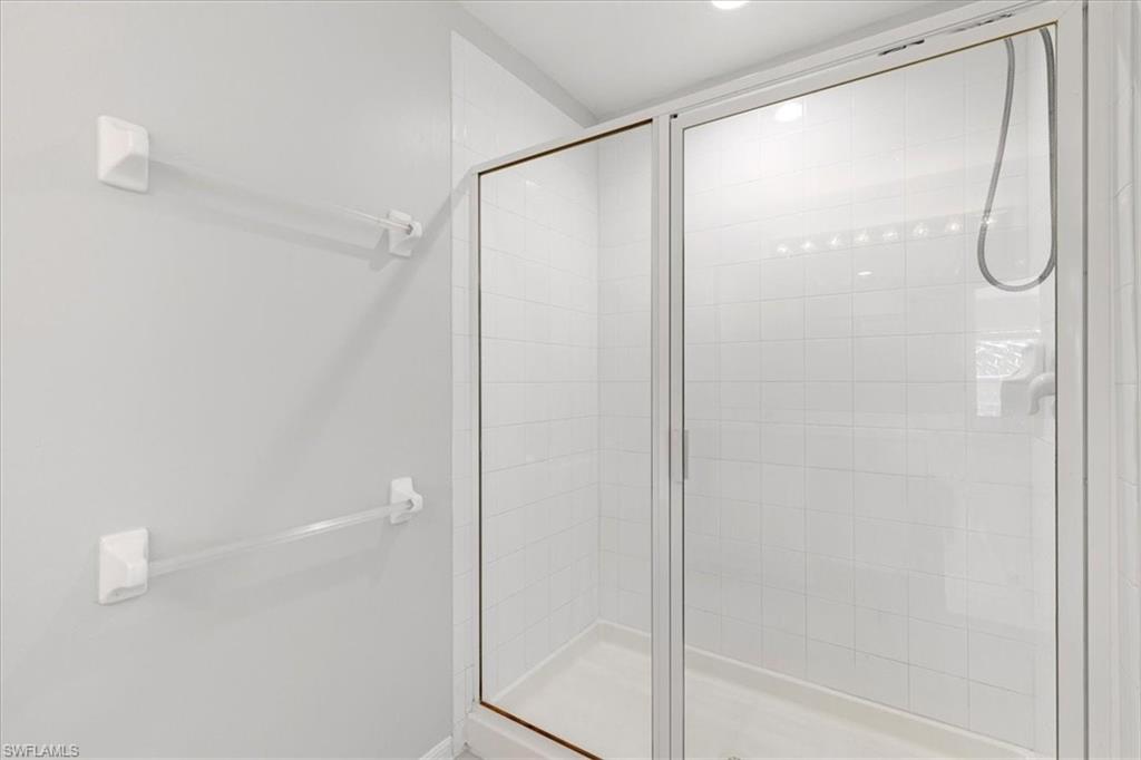 839 Hampton Circle, Unit 149 Naples, FL 34105 - Photo 14 of 22 a bathroom with a glass shower door