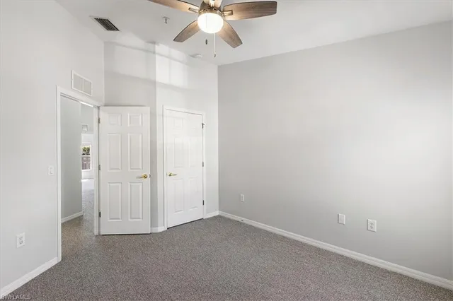 an empty room with a ceiling fan and a window