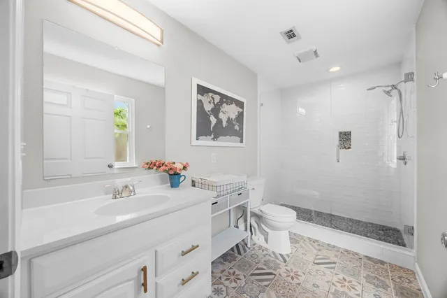 a bathroom with a sink a toilet and shower