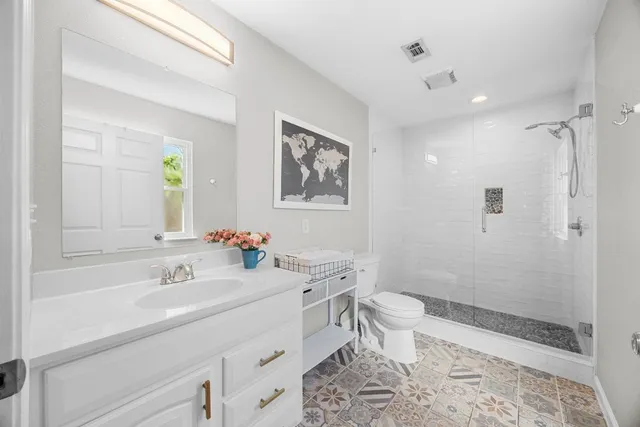 a bathroom with a sink a toilet and shower