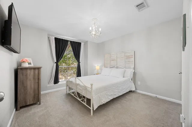 a bedroom with a bed window and flat screen tv