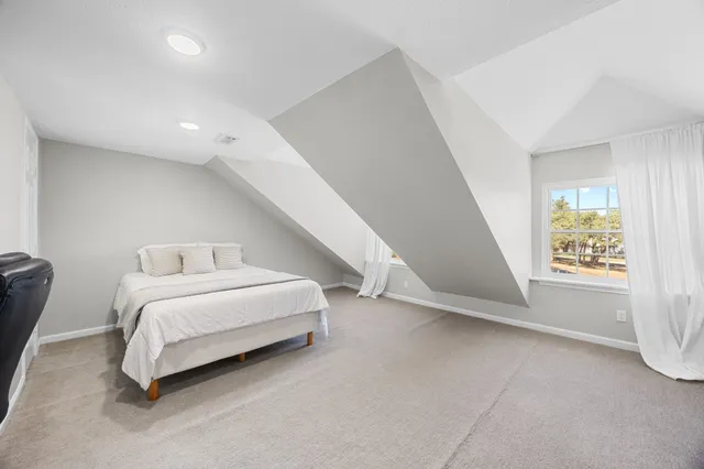 a spacious bedroom with a bed and a window