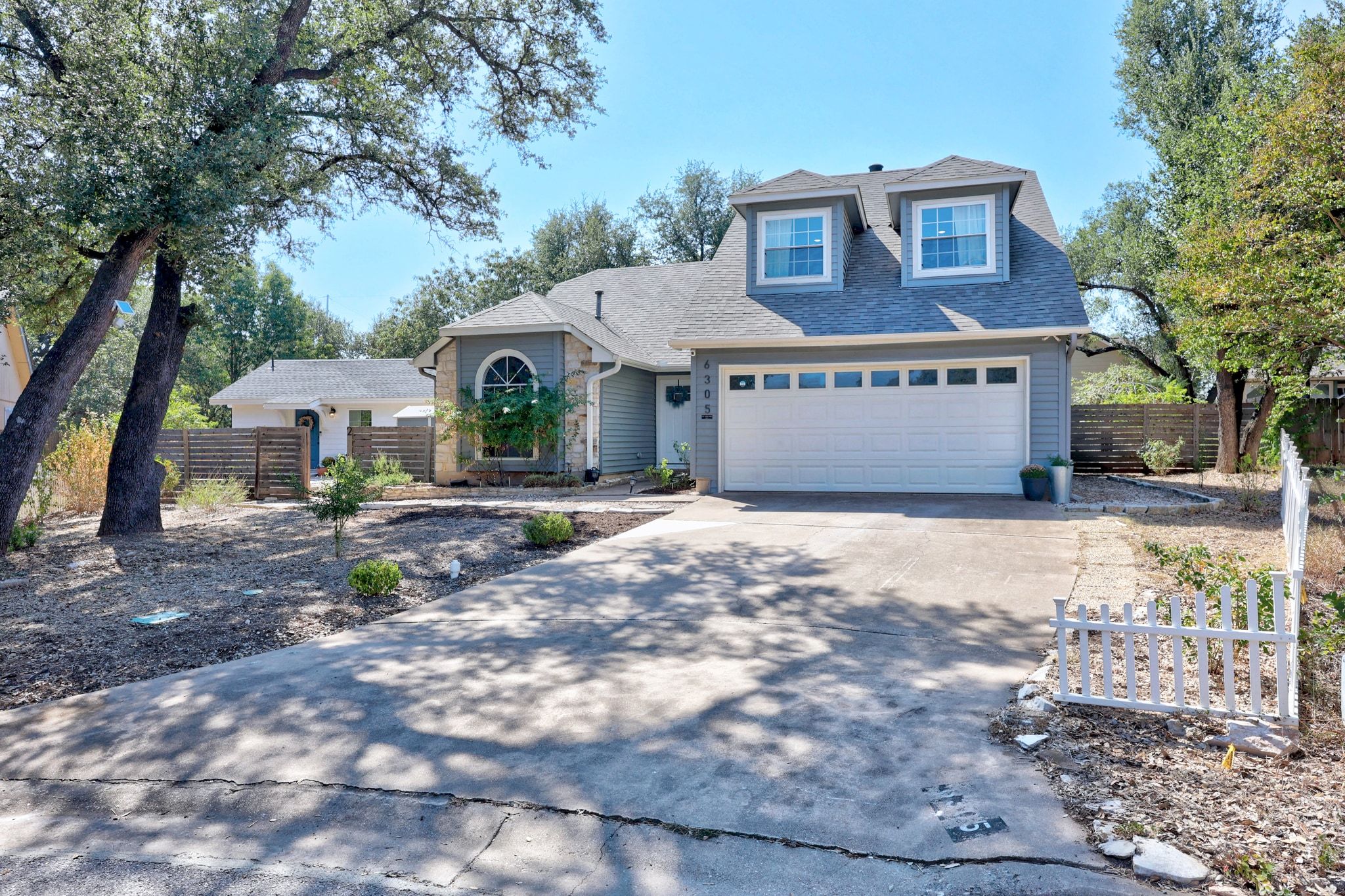 6305 Weeks Cove Austin, TX 78727 - Photo 2 of 30 Traditional home featuring concrete driveway, a garage, and a shingled roof