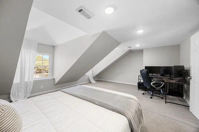 a bedroom with a bed and a chair with the wooden floor