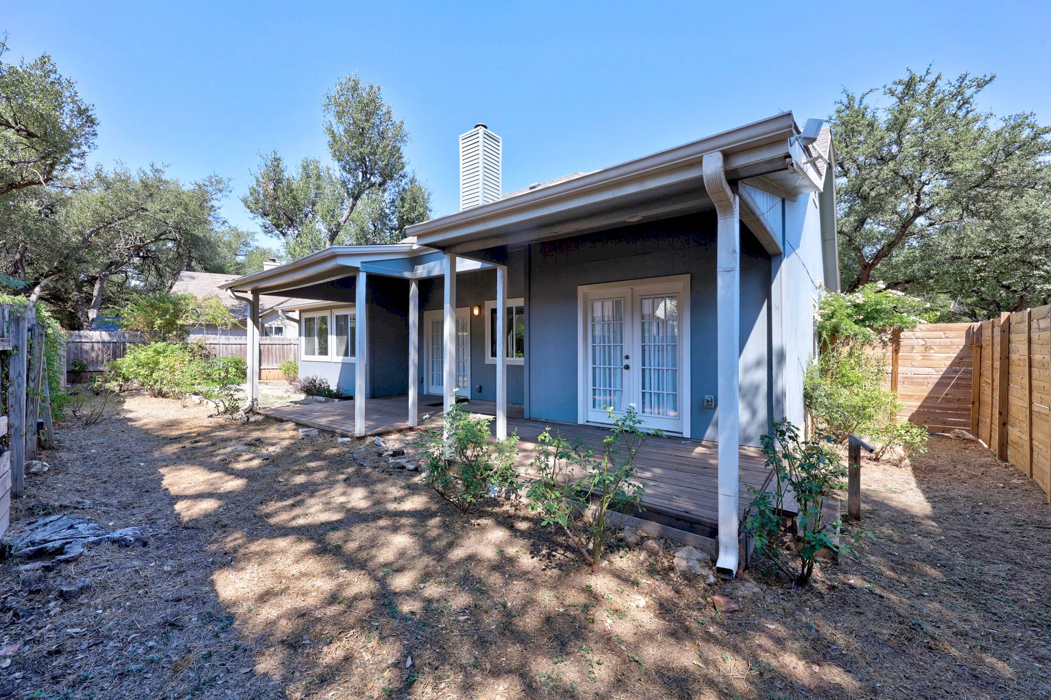 6305 Weeks Cove Austin, TX 78727 - Photo 23 of 30 Rear view of property with a fenced backyard, a chimney, and french doors