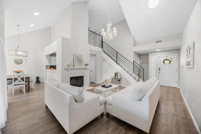 a living room with fireplace furniture and a chandelier
