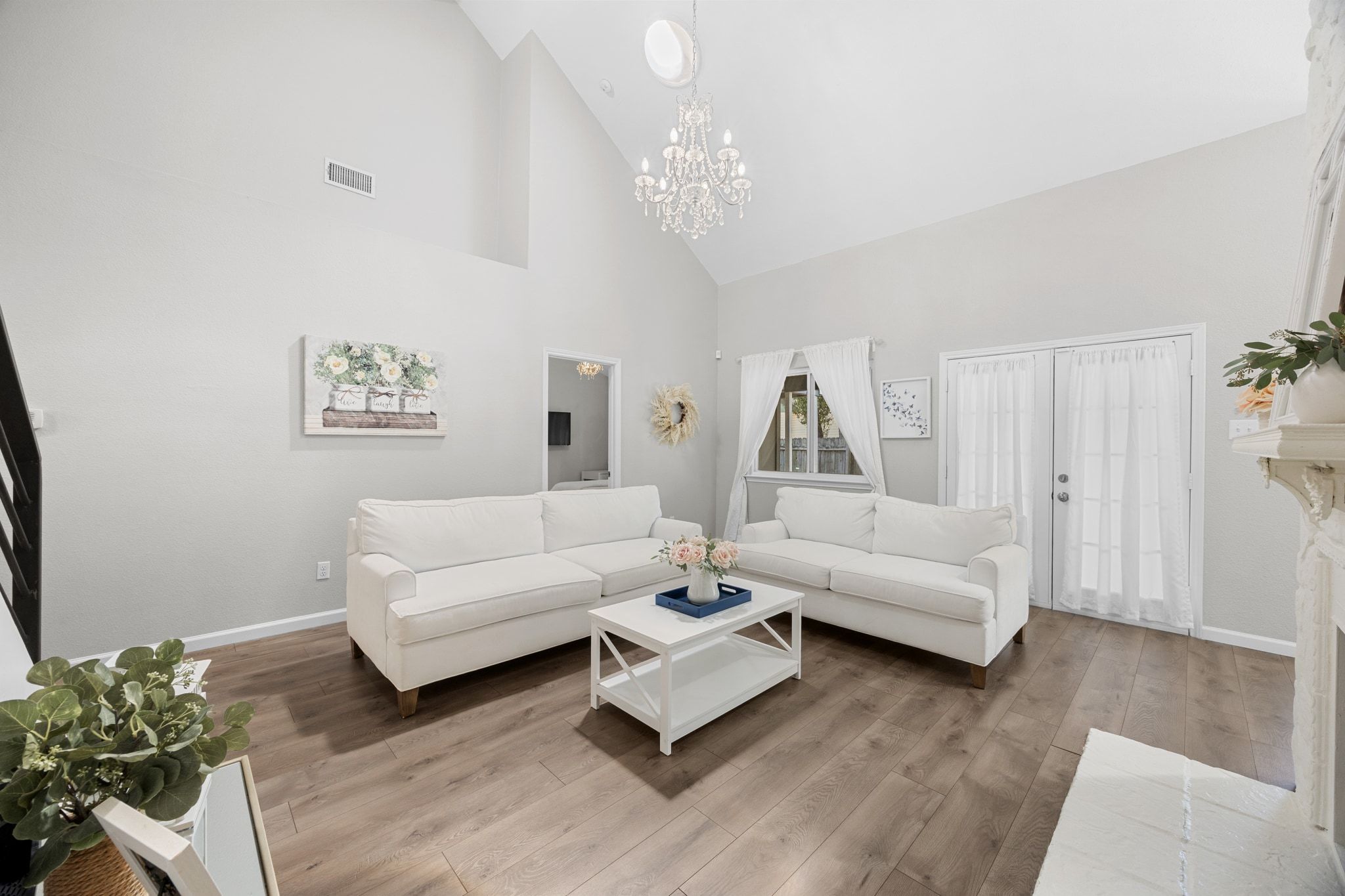 6305 Weeks Cove Austin, TX 78727 - Photo 7 of 30 Living area featuring high vaulted ceiling, light wood-style floors, and a chandelier