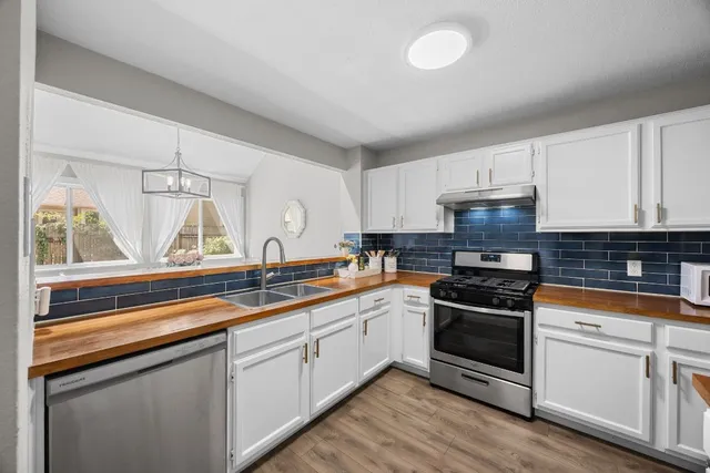 a kitchen with white cabinets and appliances