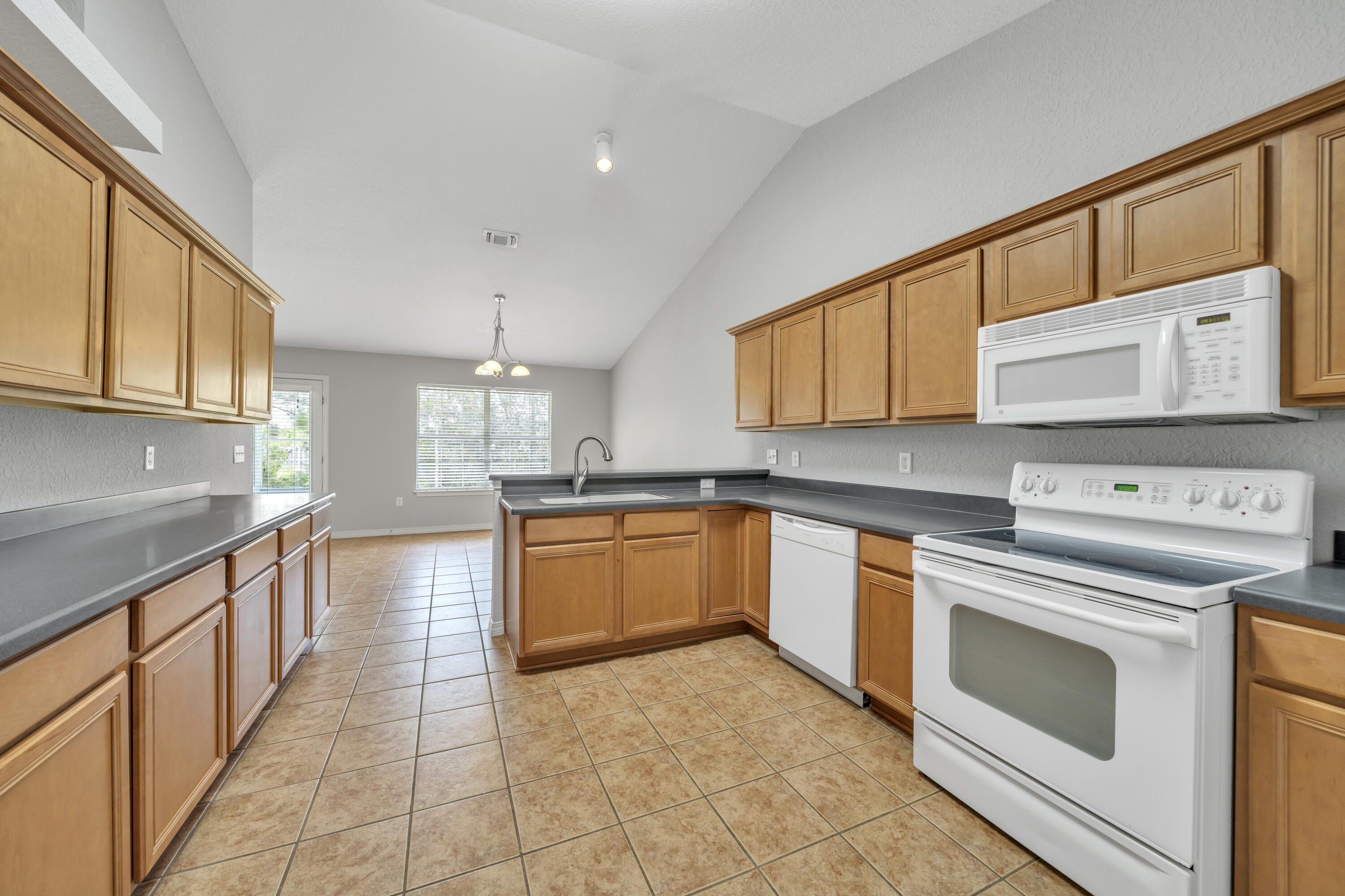 227 East Shipwreck Road Santa Rosa Beach, FL 32459 - Photo 14 of 39 a kitchen with stainless steel appliances granite countertop a stove sink and cabinets