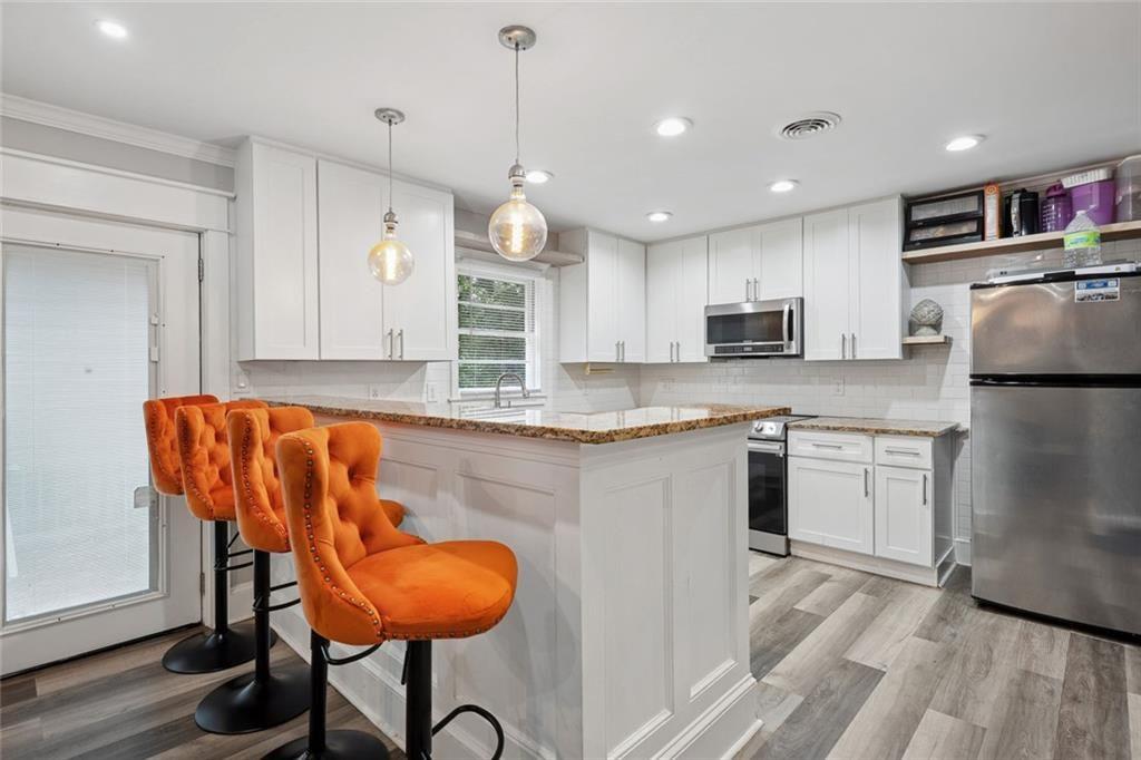 4136 Weelaunee Road Ellenwood, GA 30294 - Photo 9 of 22 a kitchen with refrigerator and microwave