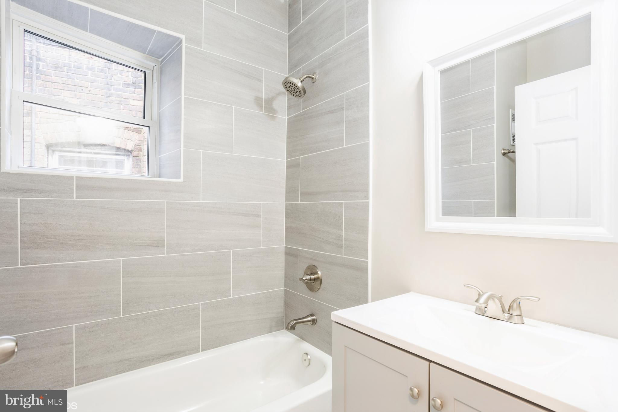 3025 Walbrook Avenue Baltimore, MD 21216 - Photo 13 of 16 a bathroom with a sink a toilet a shower and a mirror