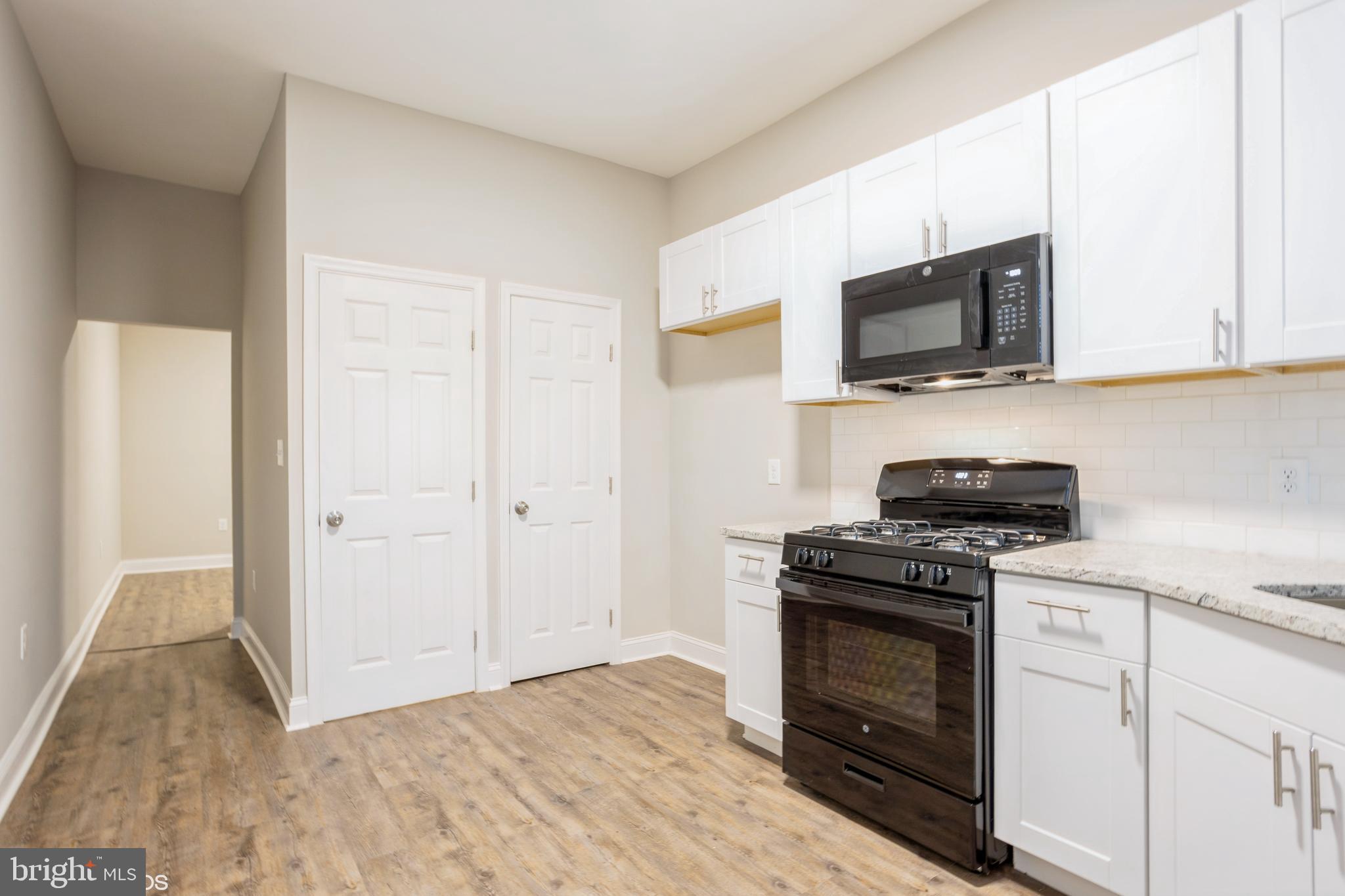 3025 Walbrook Avenue Baltimore, MD 21216 - Photo 8 of 16 a kitchen with a stove and a microwave