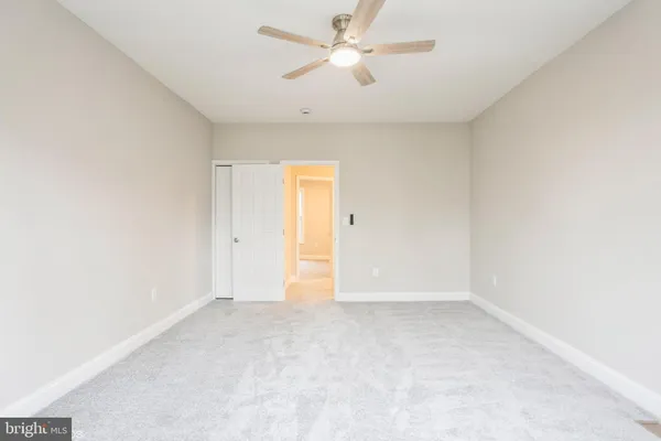 an empty room with a ceiling fan and a window