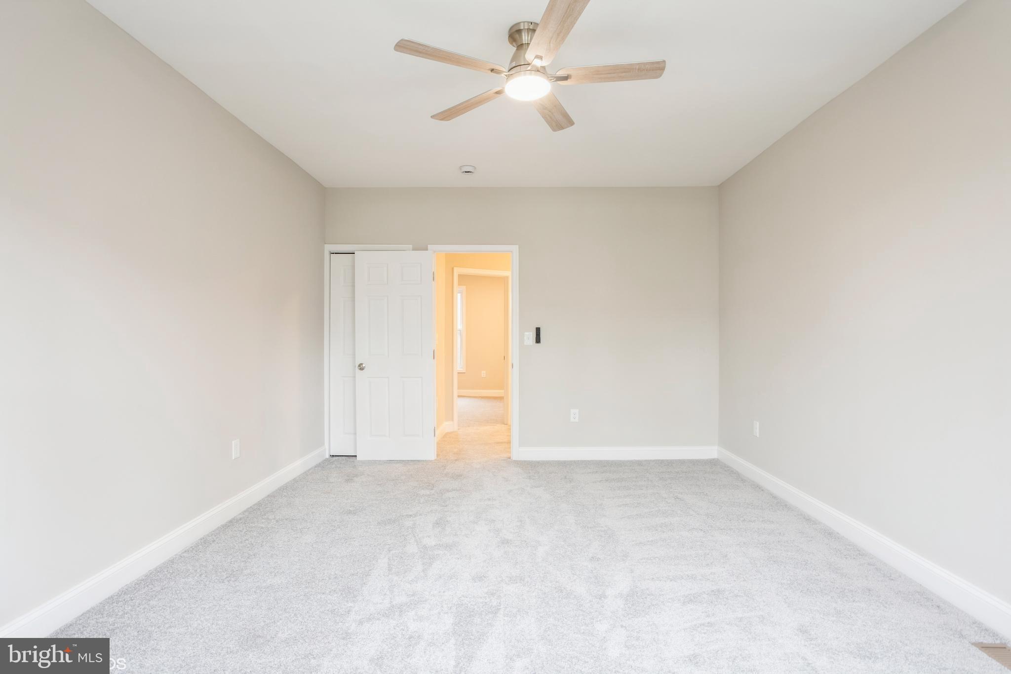 3025 Walbrook Avenue Baltimore, MD 21216 - Photo 10 of 16 an empty room with a ceiling fan and a window