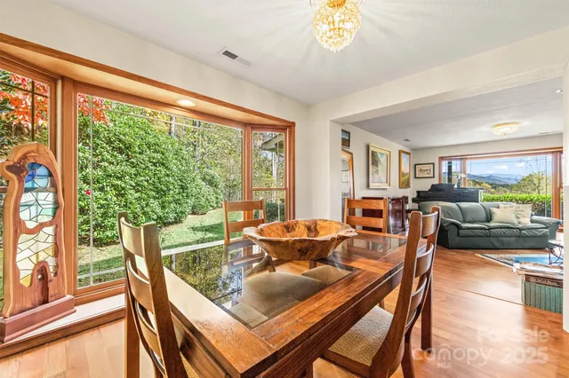 a view of a dining room with furniture large windows and wooden floor