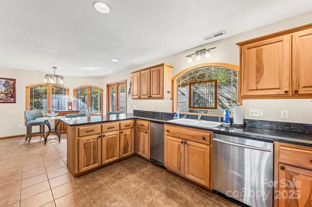 a kitchen with stainless steel appliances granite countertop a stove sink and cabinets