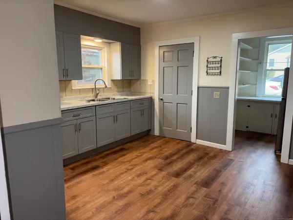 a view of an empty room with wooden floor and closet