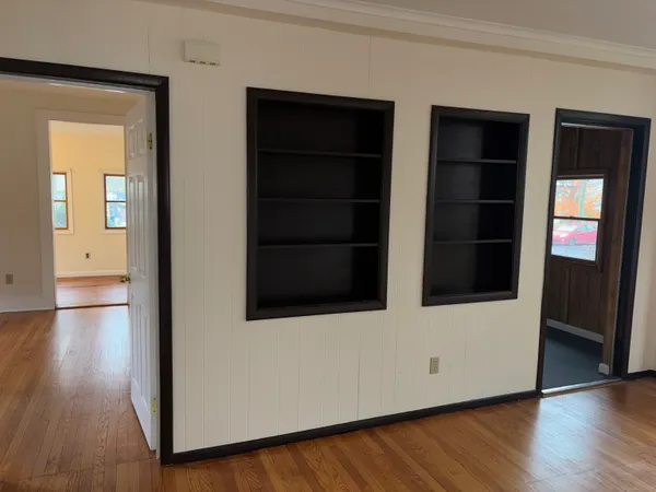 an empty room with wooden floor and windows