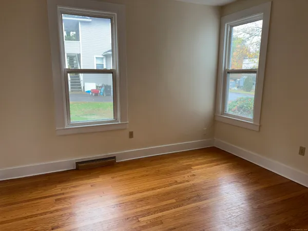 wooden floor in an empty room with a window