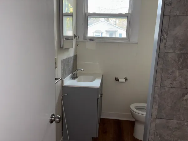 a bathroom with a toilet sink vanity and mirror