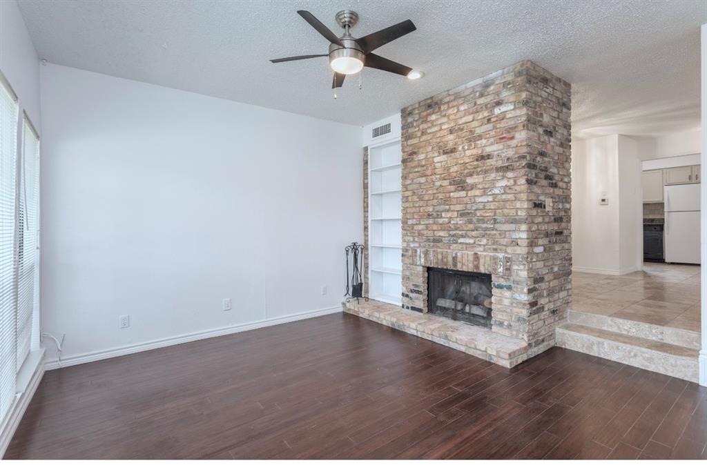 15151 Berry Trail, Unit 201 Dallas, TX 75248 - Photo 3 of 12 an empty room with a fireplace and fan