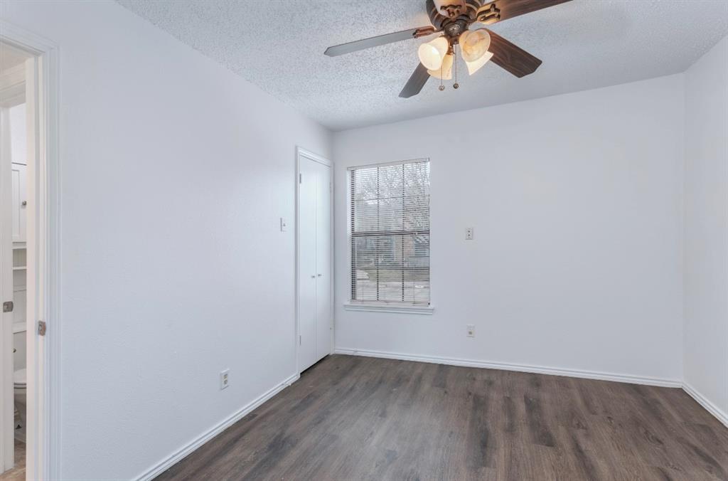 15151 Berry Trail, Unit 201 Dallas, TX 75248 - Photo 10 of 12 an empty room with wooden floor chandelier fan and windows