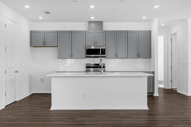 a kitchen with a refrigerator and a stove top oven