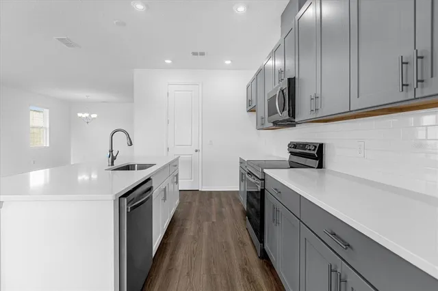 a kitchen with stainless steel appliances granite countertop a sink stove and cabinets
