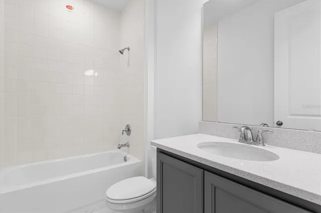 a bathroom with a granite countertop sink toilet and bathtub