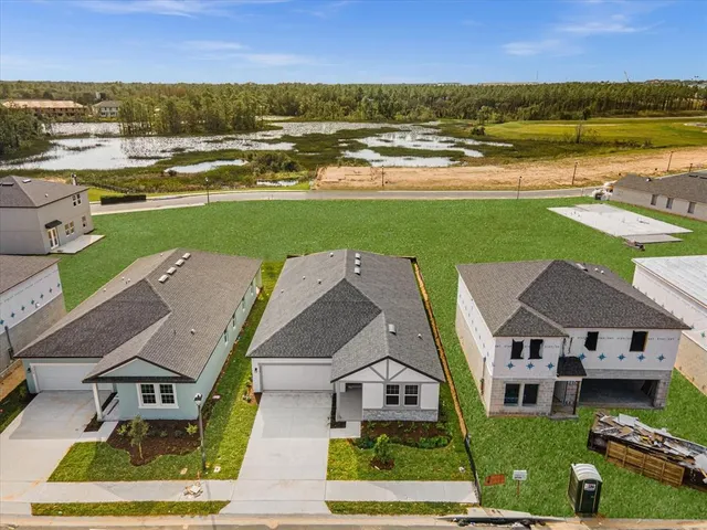 an aerial view of a house with a garden and lake view