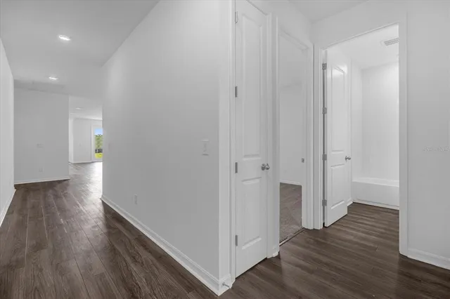 a view of a hallway with wooden floor