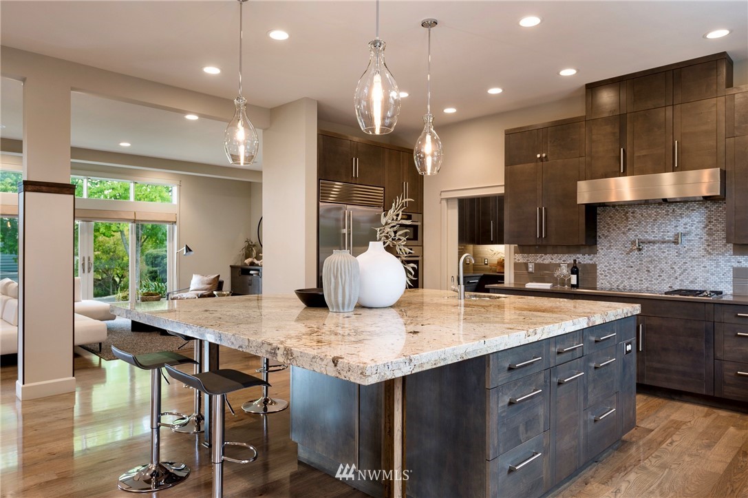 212 5th Avenue West Kirkland, WA 98033 - Photo 18 of 36 a kitchen with kitchen island granite countertop a table chairs sink and stove
