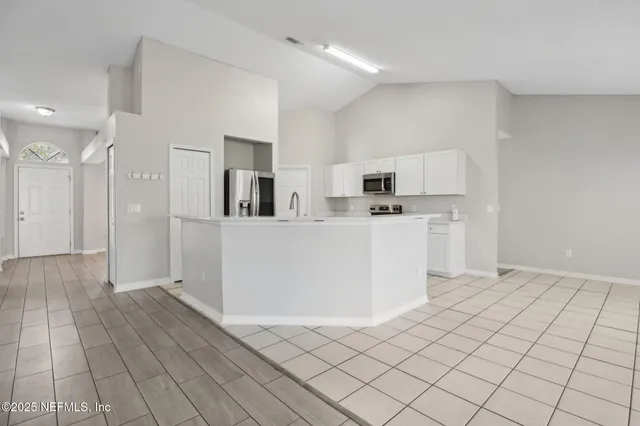 a kitchen with stainless steel appliances a refrigerator sink and cabinets