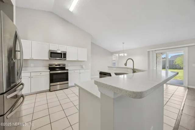 a kitchen with stainless steel appliances a sink a stove top oven a counter space and cabinets