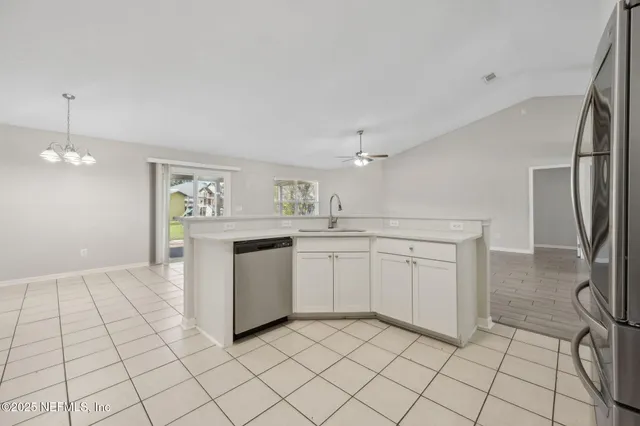 a kitchen with white cabinets a sink and appliances