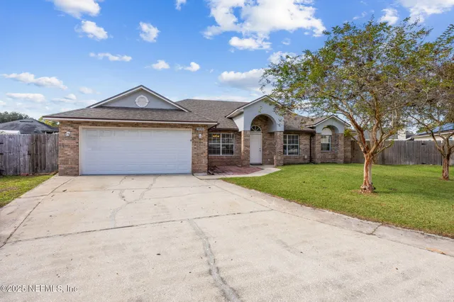 a front view of a house with a garden and trees