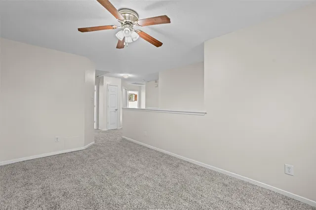 an empty room with fan and windows