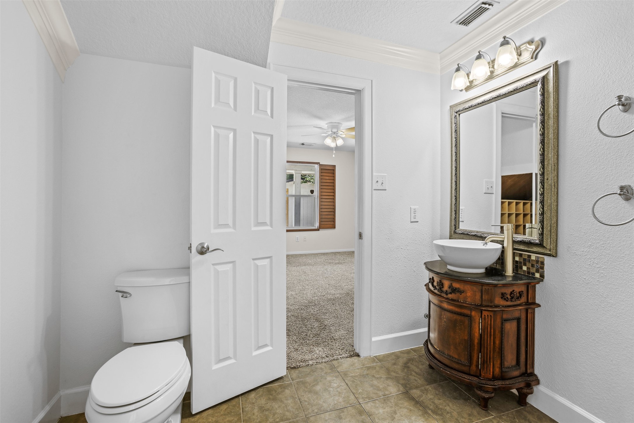 14808 Welbeck Drive Channelview, TX 77530 - Photo 17 of 36 a bathroom with a toilet a sink and mirror