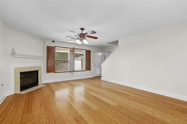 a view of an empty room with chandelier and fireplace