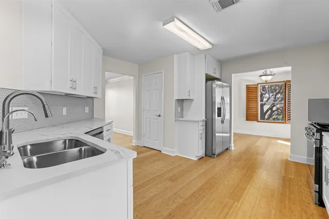 a kitchen with granite countertop a sink and refrigerator