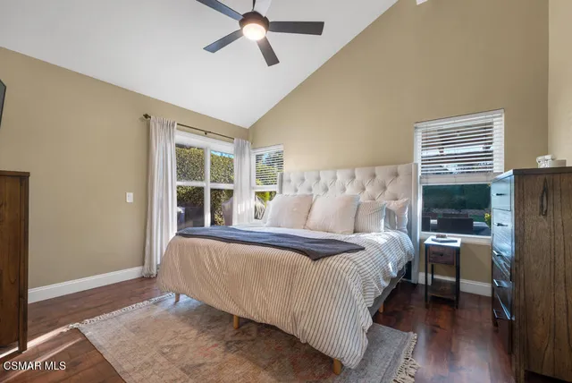 a bed sitting in a spacious bedroom next to a window and a chandelier