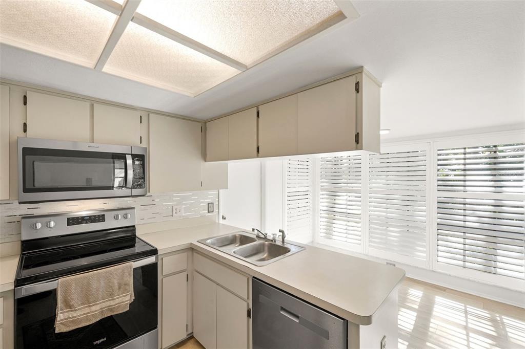 6665 Water Oak Court Spring Hill, FL 34606 - Photo 17 of 64 a kitchen with a sink stove and microwave