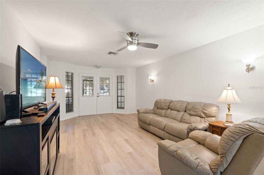 6665 Water Oak Court Spring Hill, FL 34606 - Photo 10 of 64 a living room with furniture and a flat screen tv