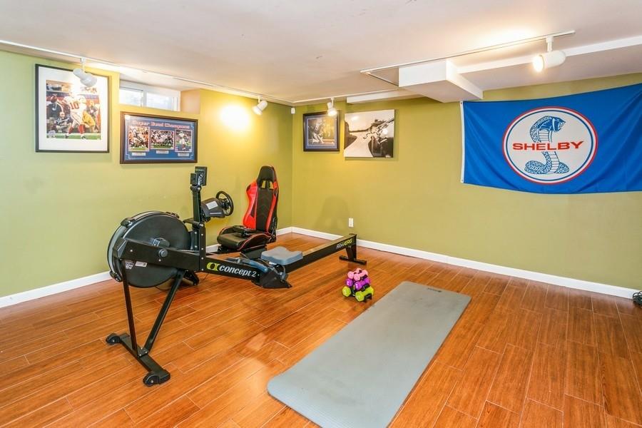 156 80th Street Brooklyn, NY 11209 - Photo 28 of 37 a room with gym equipment and wooden floor