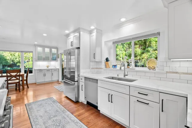 a kitchen with stainless steel appliances granite countertop a sink stove and cabinets
