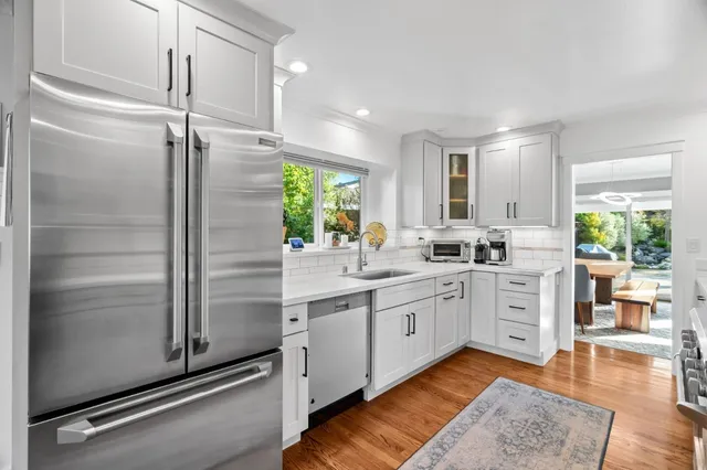 a large kitchen with a refrigerator a sink a stove and cabinets