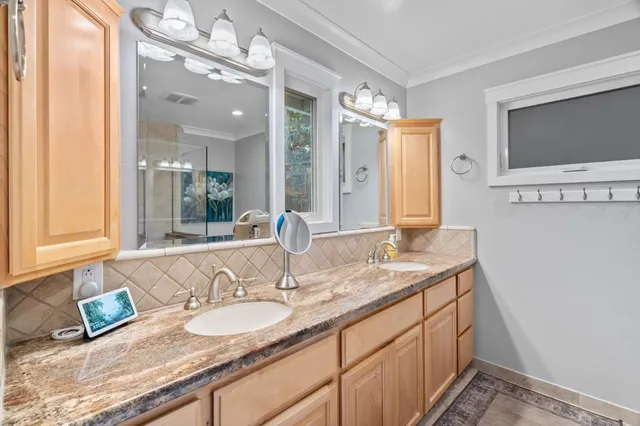 a bathroom with a granite countertop sink a mirror and a shower